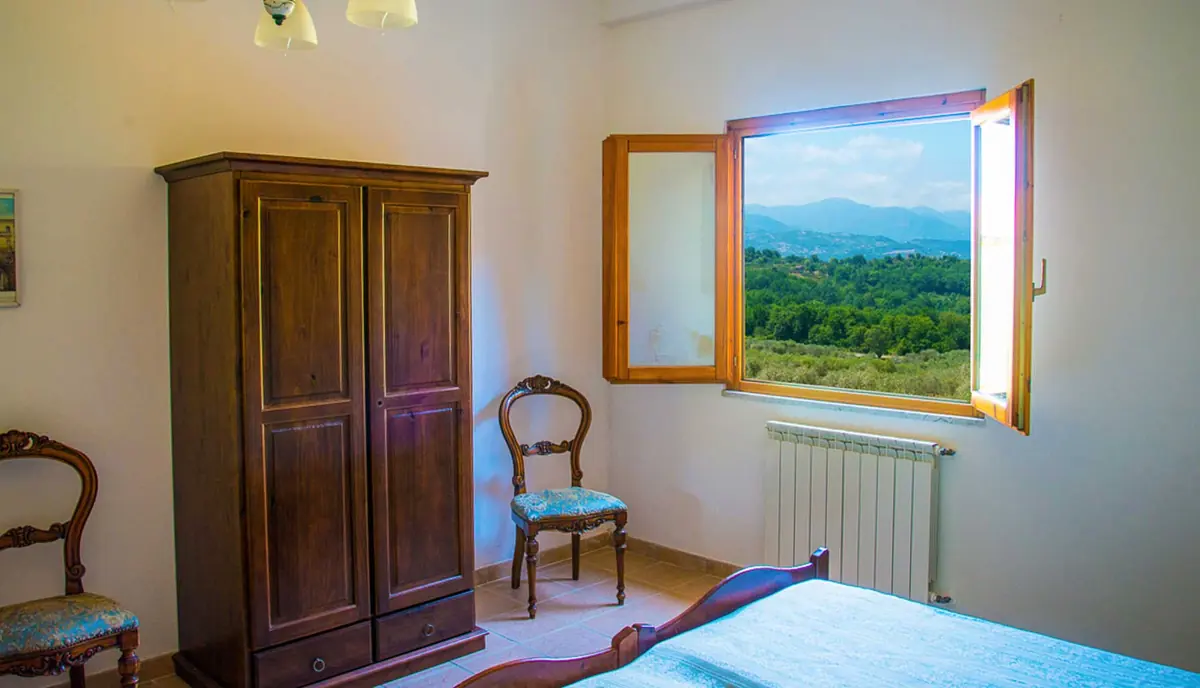 Camera con armadio in legno e finestra sulla valle